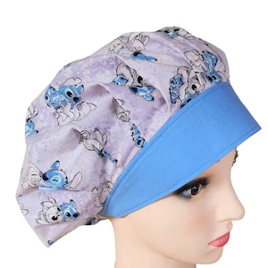 Puede incluir: Un gorro de quirófano morado y azul con un estampado de personaje de dibujos animados. El gorro tiene una visera azul y una parte superior fruncida.