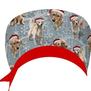 Könnte beinhalten: Ein hellblauer Stoff mit einem sich wiederholenden Muster aus Golden Retrievern mit Weihnachtsmützen, die von weißen Schneeflocken unterbrochen werden. Ein leuchtend rotes Band verläuft über den unteren Teil des Bildes und bildet einen dekorativen Rand.