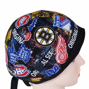 May include: A black and multi-colored hockey cap featuring logos of various NHL teams, including the Boston Bruins, Toronto Maple Leafs, and New York Rangers. The cap has a black brim and a button detail, with the words "ORIGINAL SIX" printed on the side.