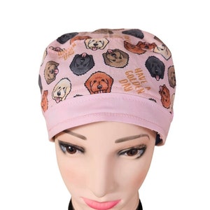 Könnte beinhalten: Rosa chirurgische Mütze mit einem Muster aus Golden Retriever-Hunden und dem Text "Have a Golden Day".
