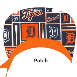 May include: A blue and orange fabric patch with the words "Detroit Tigers" and the Detroit Tigers logo. The patch is shaped like a half circle and has a white background.