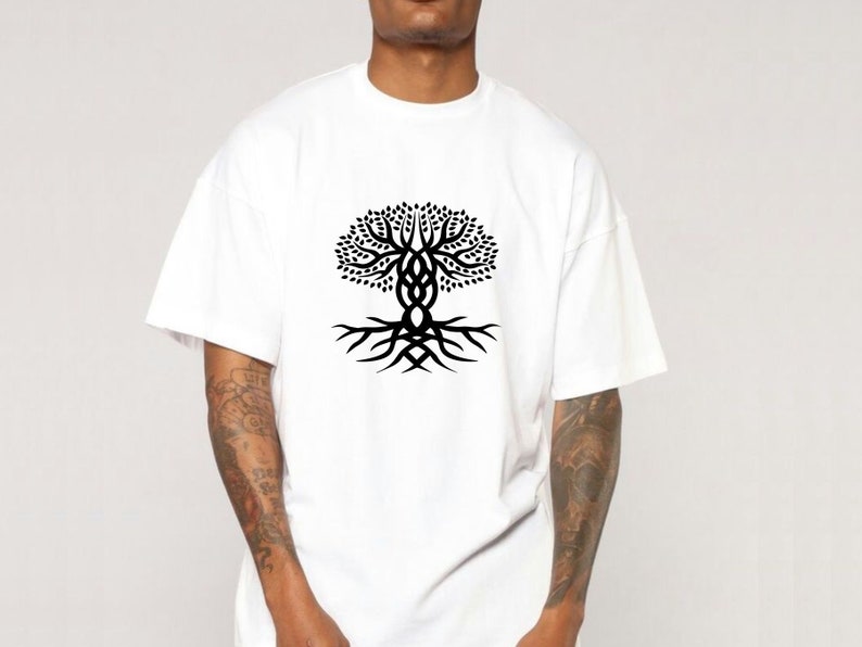 May include: White t-shirt with a black tree of life design. The graphic shows a stylized tree with detailed branches and roots, representing growth and connection. The shirt is made of a soft, comfortable material.