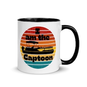 May include: White ceramic mug with a black interior and handle. The mug features a retro design with a boat silhouette and the text "I am the Captoon" in black and white, set against a sunset background.