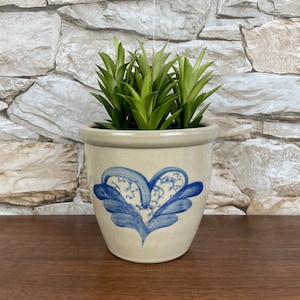 May include: A white ceramic planter with a blue heart design, featuring a green succulent plant inside.