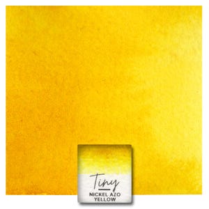 May include: A small square pan of bright yellow watercolor paint. The pan is labeled "Tiny Nickel Azo Yellow".