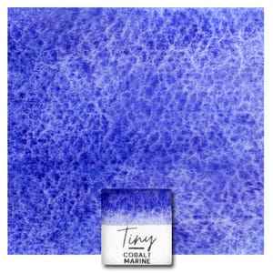 Op de afbeelding: Een close-up van een blauwe aquarelverf met een witte gradiënt. De verf is gelabeld met "Tiny Cobalt Marine".