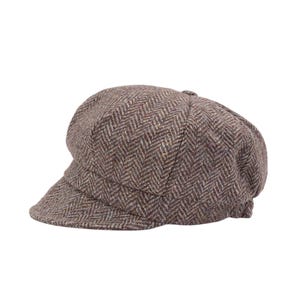 Puede incluir: Gorra de estilo newsboy marrón con estampado de espiga. La gorra presenta una corona redondeada y una visera corta y rígida. La tela tiene un aspecto texturizado con hilos marrones, beige y morados.
