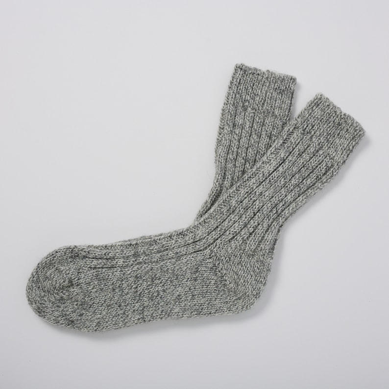 May include: A pair of gray wool socks with a ribbed texture. The socks are made of a soft, comfortable material and are perfect for keeping your feet warm in the winter.