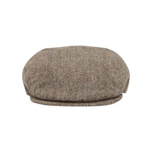 Könnte beinhalten: Eine braune Tweed-Flatcap mit Fischgrätenmuster.