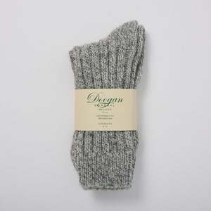 May include: Gray wool walking socks with a white label that reads "Doegan Donegal Ireland Est 1988 Irish Walking Socks 100% pure wool To Fit Shoe Size 8-12"