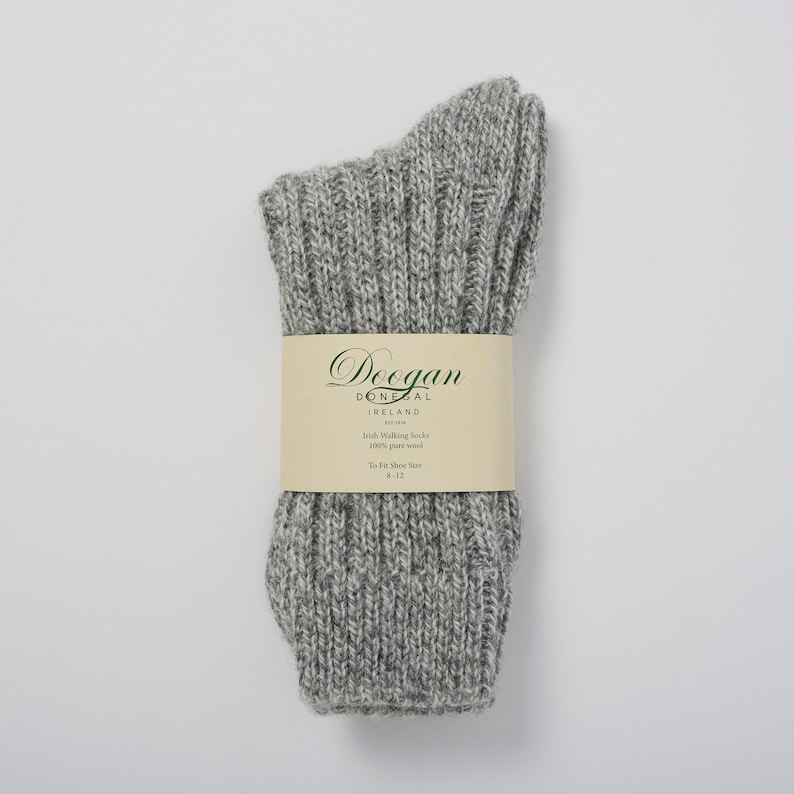 May include: Gray wool walking socks with a white label that reads "Doegan Donegal Ireland Est 1988 Irish Walking Socks 100% pure wool To Fit Shoe Size 8-12"