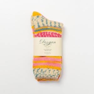 May include: A pair of Irish walking socks with a colorful pattern. The socks feature a cream-colored toe and heel, with pink, yellow, and blue stripes and accents. The socks are labeled with the brand name "Doogan Donegal Ireland".