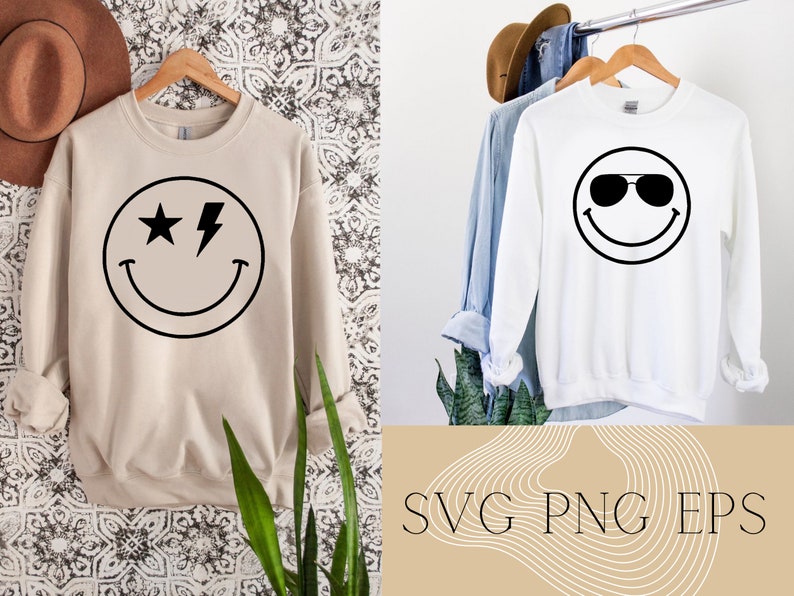 May include: Two white sweatshirts with black smiley face designs. One smiley face has a star and lightning bolt for eyes. The other smiley face has sunglasses. The text "SVG PNG EPS" is on a tan background with white wavy lines.