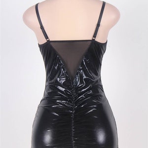 以下が含まれることがあります： 背中がメッシュパネルになった、黒いフェイクレザーのミニドレス。ドレスは体にフィットしたシルエットで、後ろはギャザーが入っています。