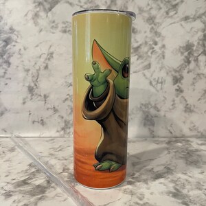 Left side of tumbler and baby yoda reaching for the sky