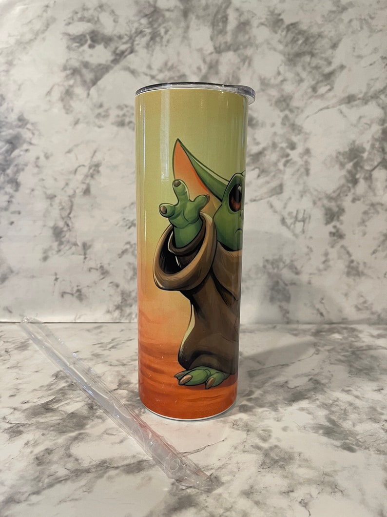 Left side of tumbler and baby yoda reaching for the sky