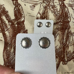 Könnte beinhalten: Ein Paar Ohrringe aus Sterlingsilber mit einem floralen Design. Die Ohrringe werden auf einer weißen Karte mit dem Text "STERLING SILVER" auf der Unterseite präsentiert.