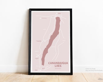 May include: A black framed print of a map of Canandaigua Lake, New York, with the lake highlighted in pink. The text "Canandaigua Lake" and "Wineries" is printed below the map.