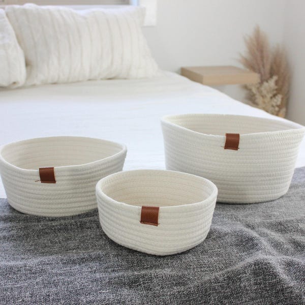 Cesta redonda de cuerda de algodón tejida blanca con detalles de cuero