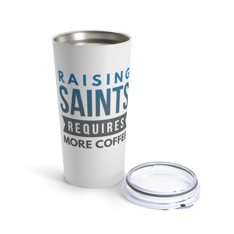 May include: White stainless steel travel mug with a blue and grey design that says "Raising Saints Requires More Coffee".