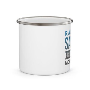 May include: White enamel camping mug with a silver rim. The mug has a blue and gray graphic that says "Raise a Salute to the Real Ones. More Than Just Friends."
