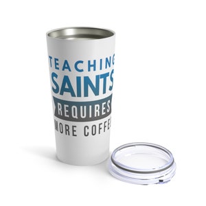 Puede incluir: Taza de viaje de acero inoxidable blanca con un dise&ntilde;o azul y gris que dice "Ense&ntilde;ar a los santos requiere m&aacute;s caf&eacute;".