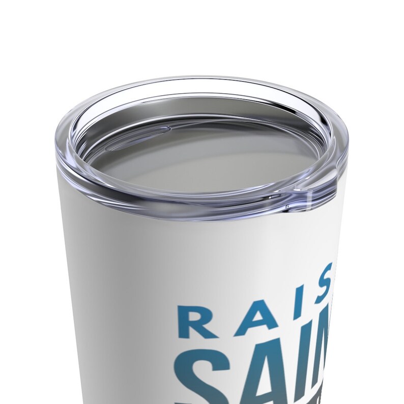 May include: White stainless steel travel mug with a blue and white gradient design that says "Raise Saints".