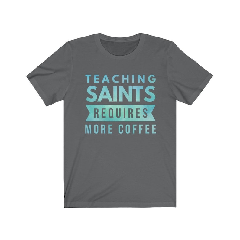 Peut inclure: Un t-shirt gris fonc&eacute; avec un design d&eacute;grad&eacute; bleu et vert. Le texte sur le t-shirt est "Teaching Saints Requires More Coffee".