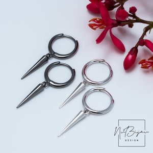 May include: A pair of hoop earrings with a pointed dangle. One pair is silver and the other is black.