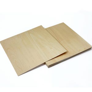 May include: A stack of light-colored wooden boards, possibly plywood, with visible wood grain. The boards are rectangular and appear to be new, with a smooth surface. The image is taken against a white background, highlighting the natural wood tones.