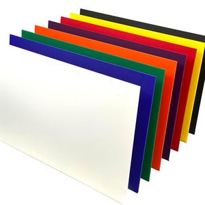 May include: A set of eight colorful sheets of plastic, arranged in a fan shape. The colors are white, blue, green, orange, red, purple, yellow, and black.