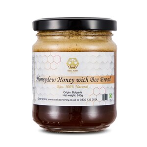 May include: A jar of honeydew honey with bee bread, with a black lid and a white label. The label states "Honeydew Honey with Bee Bread" and "Raw 100% Natural". The net weight is 240g.