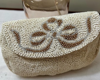 May include: A white beaded clutch with a floral design in brown beads.