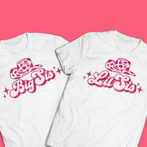 Puede incluir: Dos camisetas blancas con texto y gráficos rosas. Una camiseta dice "Big Sis" y la otra dice "Lil Sis". Cada camiseta presenta un gráfico de sombrero de vaquero con un patrón rosa y blanco y acentos de estrella.