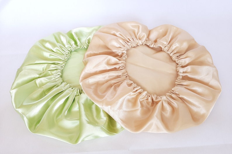Puede incluir: Dos gorros de sat&eacute;n. Uno es de color verde claro y el otro de color beige claro. Ambos gorros tienen una banda el&aacute;stica alrededor del borde para mantenerlos en su lugar. Los gorros est&aacute;n hechos de una tela brillante y suave.