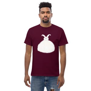 May include: A maroon t-shirt with a white fluffy rabbit graphic on the front.