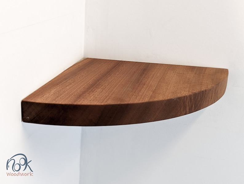 A mahogany shelf is installed on the corner of a wall.