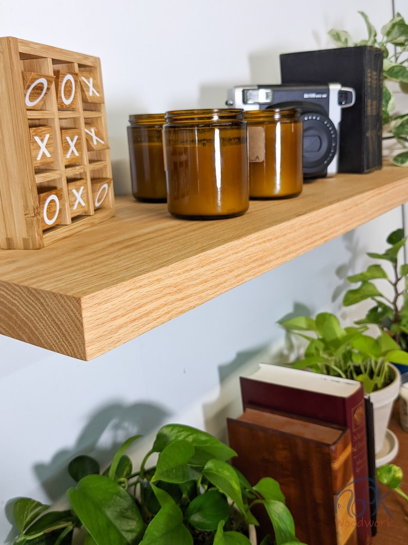 A quality shelf will hang on the wall without showing a bracket as the thick oak shelf demonstrates here 