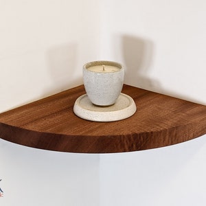 A candle is displayed on the mahogany corner shelf.