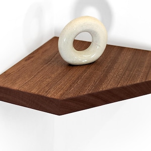 A mahogany corner floating shelves displays a donut sculpture