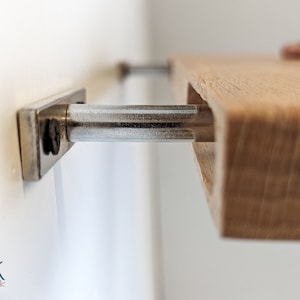 Close up side view of the oak shelf sliding onto the two metal brackets