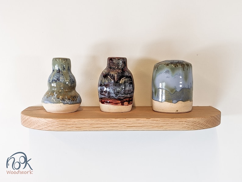 Front view of three vases sitting atop an oak shelf with soft beveled and rounded corners