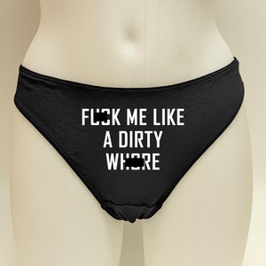 Könnte beinhalten: Schwarzer Slip mit weißem Text "FUCK ME LIKE A DIRTY WHORE". Die Unterwäsche wird auf einer Schaufenquinpuppe präsentiert.