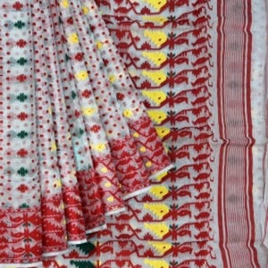 May include: White saree with red, yellow, and green geometric patterns. The saree has a white base with a red border and a repeating pattern of red, yellow, and green geometric shapes.