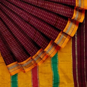 May include: A maroon and gold saree with a checkered pattern and a border of stripes in green, yellow, and maroon.