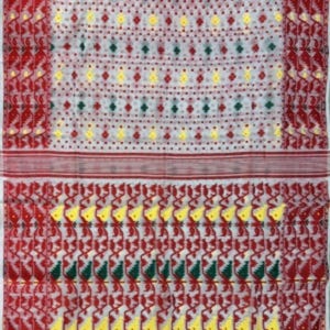 May include: White saree with a red and green border. The saree has a repeating pattern of small yellow and red flowers.