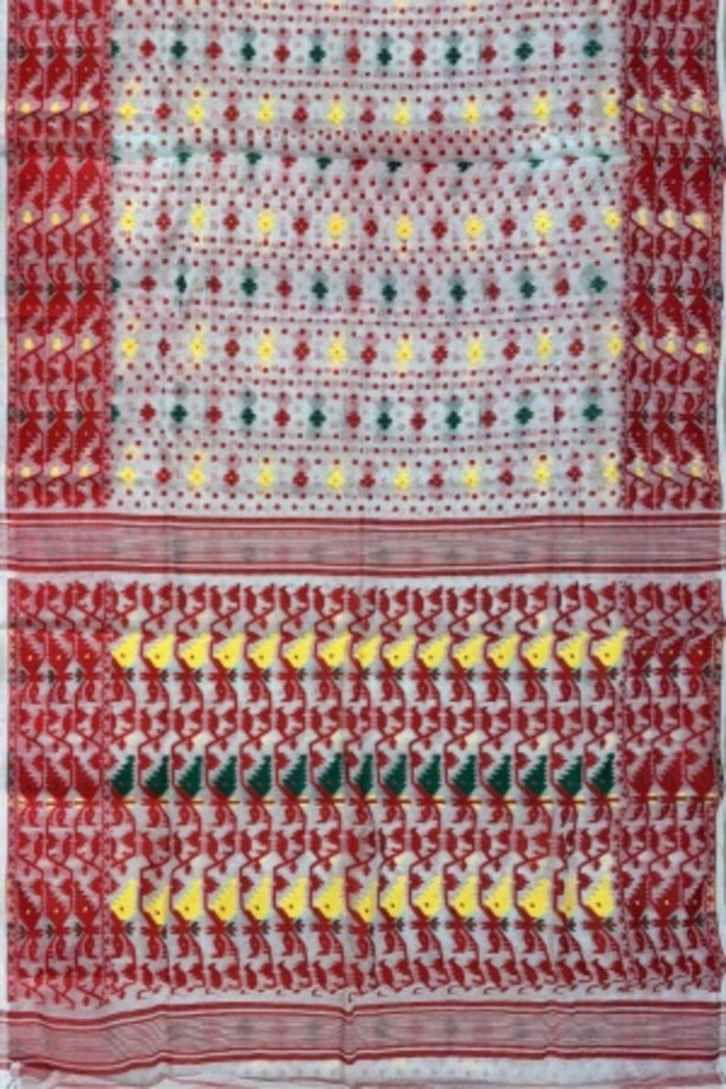 May include: White saree with a red and green border. The saree has a repeating pattern of small yellow and red flowers.