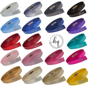 May include: A collection of 18 spools of satin ribbon in various colors, including white, silver, coffee, black, saxe, royal blue, navy blue, red, cardinal, purple, pale pink, bronze, blush, rose, aqua, fuchsia, ivory, antique gold, and daffodil. The spools are arranged in three rows of six, with the word "CUSTOMISE hq" in the center.