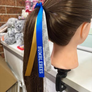 Nastri per capelli personalizzati da 15 mm con scritta "College Font" x 3 colori, con pallone da netball.