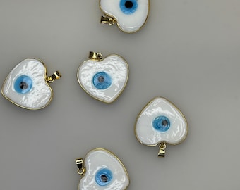 Colgante con dije de corazón blanco con ojo turco y detalles dorados de cristal